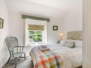 牛顿斯图尔特Priory Walk的卧室配有床、椅子和窗户。