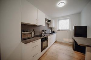 科布伦茨FR02 - Design Apartment Koblenz City - 1 Bedroom的厨房铺有木地板,配有白色橱柜。