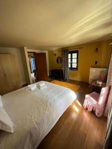 莫诺登德里Arktouros Hotel的卧室配有一张白色的大床,铺有木地板