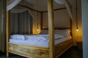 阿鲁沙Hakuna Woga Inn的卧室配有带白色床单的天蓬床
