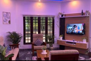 科钦Hosted by Resmi Jayalal的一间带电视和沙发的客厅