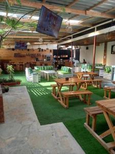 Kitengela The Crib House-Kitengela的餐厅设有木桌、椅子和平面电视。
