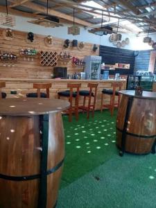 Kitengela The Crib House-Kitengela的餐厅内带木凳和桌子的酒吧