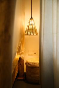阿鲁沙Hakuna Woga Inn的一间设有床和挂灯的房间