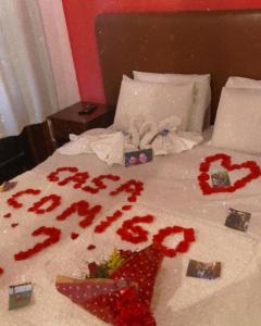 Núcleo MauáHotel Casa Alpina的一张带红色鲜花的床和床罩