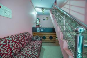 鲁德拉普尔SPOT ON Komfort Guest House的带沙发和楼梯间的房间