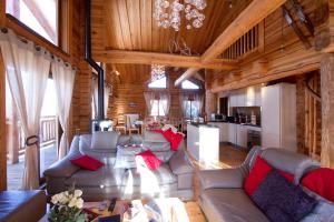 莱德萨阿尔卑斯Odalys Chalet Leslie Alpen 2的带沙发的客厅和小屋内的厨房