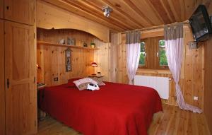 莱德萨阿尔卑斯Odalys Chalet Leslie Alpen 2的木制客房内的一张红色床