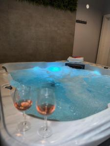 奥西耶克XXL rooms&spa的两杯葡萄酒坐在热水浴池旁