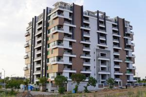 Dhok Sandemār2 BED FURNISHED APARTMENT的一座高高的公寓楼,设有许多窗户
