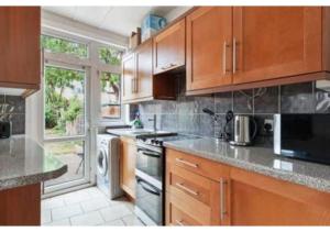 米查姆Chic 4BR Home in Mitcham Ideal for Families的厨房配有木制橱柜和炉灶烤箱。