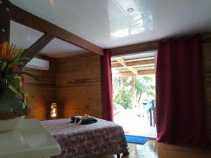 HaapuManta Lodge avec 4x4 Pleine nature的客房设有床和大窗户。