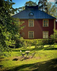 ÄlvkarlebyOfficersvillorna, Älvkarleby Vandrarhem的一间红色的房子,前面设有一张野餐桌