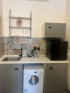 多尼杜纳约维采Penzion Lederer的厨房配有洗衣机、水槽和微波炉