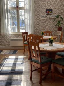 ÄlvkarlebyOfficersvillorna, Älvkarleby Vandrarhem的一间带木桌和椅子的用餐室