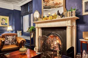 伦敦德里The Lawrence的客厅设有壁炉、椅子和桌子