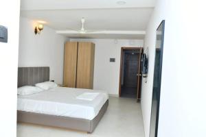 DevarkondaSWAGATH RESIDENCY的卧室配有白色的床和推拉门。