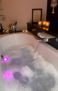 博尔赫隆De Verborgen Parel的浴缸里装满水,配有粉红色的灯光