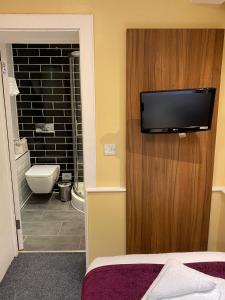 伦敦城市大陆伦敦肯辛顿酒店的一间带卫生间的浴室和墙上的电视