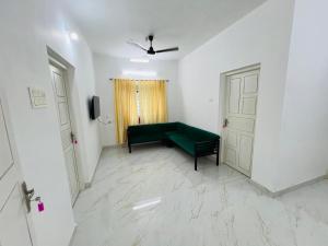 ThanniyamFurnished 2 BHK Family Apartments near Triprayar Shree Rama Temple - Beevees Homes Thriprayar的客厅设有绿色沙发和门。