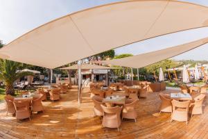 波尔托罗Hotel Mirna - Terme & Wellness Lifeclass的一个带桌椅的大伞下的露台