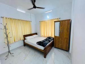 ThanniyamFurnished 2 BHK Family Apartments near Triprayar Shree Rama Temple - Beevees Homes Thriprayar的一间小卧室,配有一张床和镜子