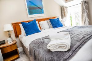诺里奇黑天鹅宾馆的一间卧室配有一张带蓝色和白色枕头的床