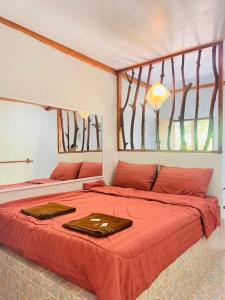 西考สบายคันทรีรีสอร์ท ปากเมงSa-buy country resort Pak Meng的一间卧室配有一张带红色床单的床和一扇窗户。