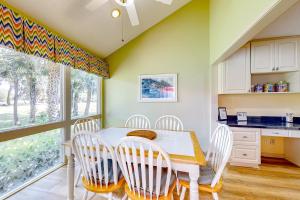 希尔顿黑德岛Windward Village 109的厨房配有桌椅和窗户。
