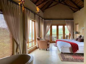 贝拉贝拉Reedbuck Lodge @Cyferfontein in Mabalingwe Reserve的一间卧室配有一张床、浴缸和窗户。