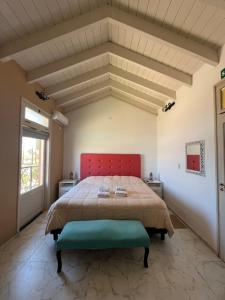 巴雷阿尔Posada Villa Pituil的一间卧室配有一张大床和红色床头板