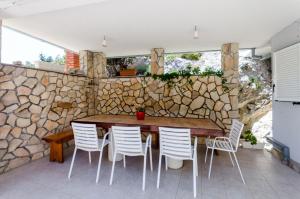 Gornje SeloHouse Ancica的一间设有石墙和木桌及椅子的用餐室