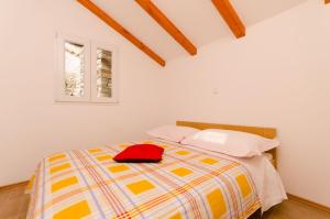 Gornje SeloHouse Ancica的一间卧室,配有一张红色帽子的床