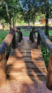 新彼得罗波利斯L'esperienza - Pousada Butique - Ecoturismo的树木繁茂的公园里的木桥