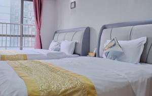 广州广州友家服务公寓的配有窗户的酒店客房内的两张床