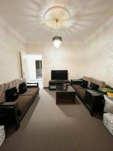 卡萨布兰卡L'Appartement Harmonia Cozy的客厅配有两张沙发和一台电视