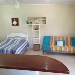 圣塞巴斯蒂安Rancho do Capitão Boiçucanga的一间卧室配有一张床和一张沙发