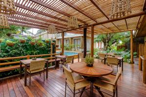 费尔南多 - 迪诺罗尼亚Vila Sal Noronha的一个带桌椅的户外庭院和一个游泳池