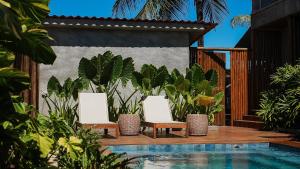 费尔南多 - 迪诺罗尼亚Vila Sal Noronha的两把椅子和一个种植了植物的后院游泳池