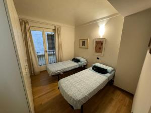 卡萨莱蒙费拉托CENTRO STORICO Eleganza e Lusso nel Monferrato的小房间设有两张床和窗户