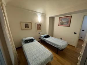 卡萨莱蒙费拉托CENTRO STORICO Eleganza e Lusso nel Monferrato的一间客房内配有两张床的房间