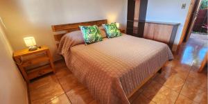 安加罗阿Cabañas Tupuna Lodge的一间卧室配有一张床和一张带台灯的桌子