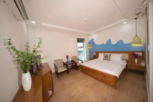 头顿Summer Beach Hotel Vung Tau的一间卧室配有一张床和一张桌子及椅子