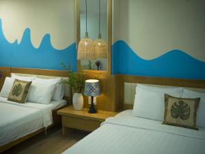头顿Summer Beach Hotel Vung Tau的一间卧室设有两张床和蓝白色的墙壁