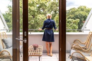 雷德尼斯Resort Lednice - Eisgrub的站在窗外的阳台上的女人