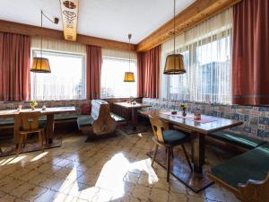 滨湖采尔Gästehaus Bleiweis-Zehentner的餐厅设有桌椅和窗户。
