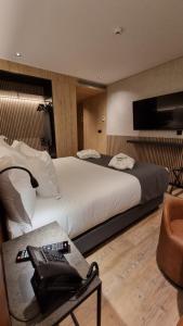 里斯本Hotel Principe Avila的酒店客房设有一张大床和一张桌子。