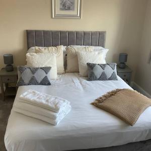 阿什伯恩Beautiful Cottage in Ashbourne的一张配有白色床单和枕头的大床