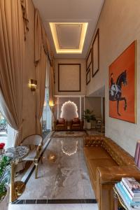 胡志明市Golden Tree Hotel & Apartment的客厅配有沙发,墙上有马匹