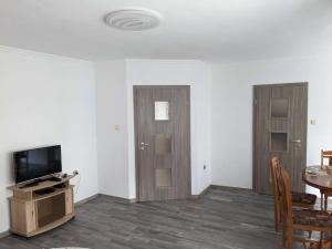 布尔加斯Lazur Apartment的客厅配有桌子、电视和门